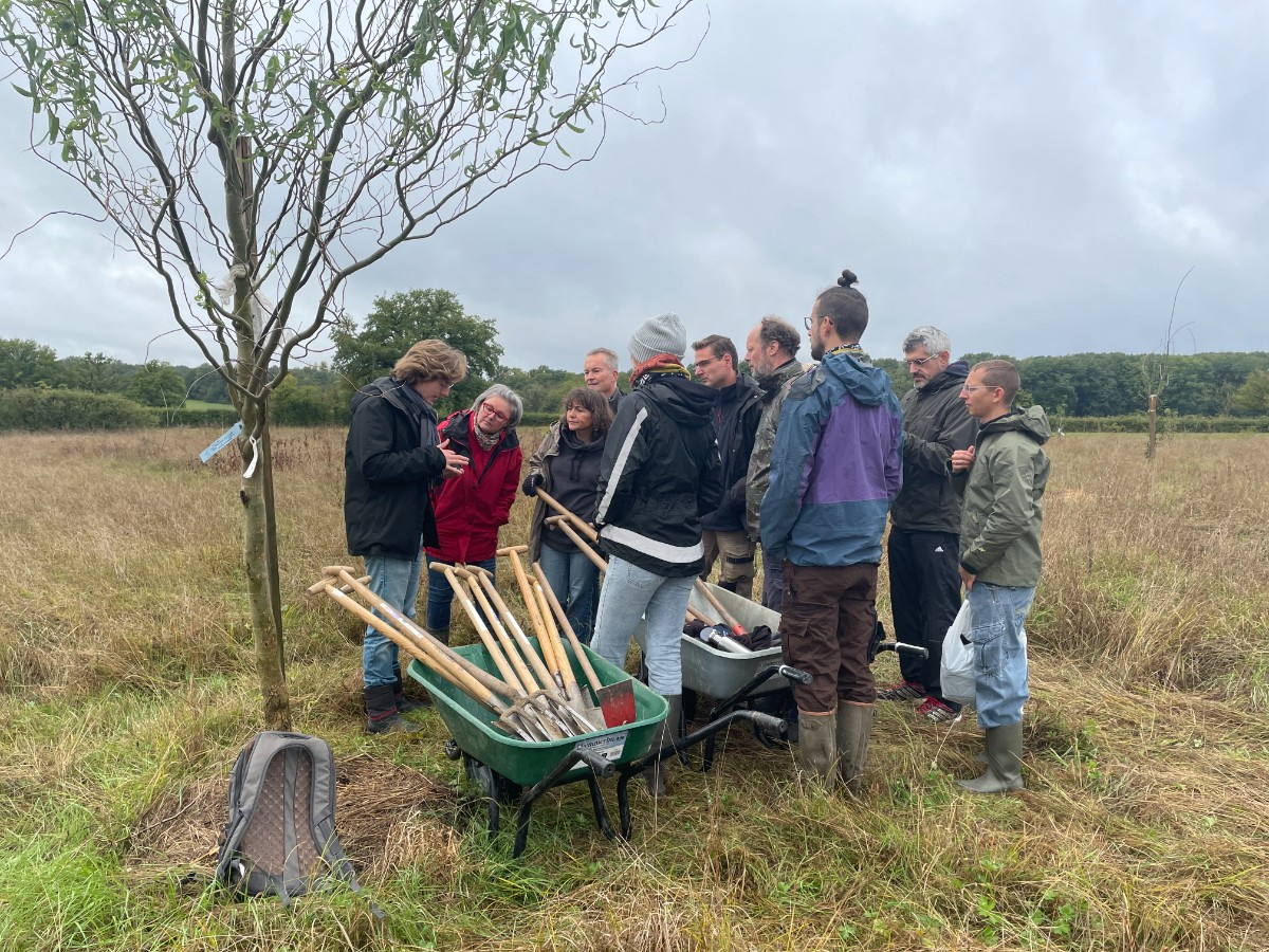 Un groupe près à jardiner, avec une brouette remplie d'outils